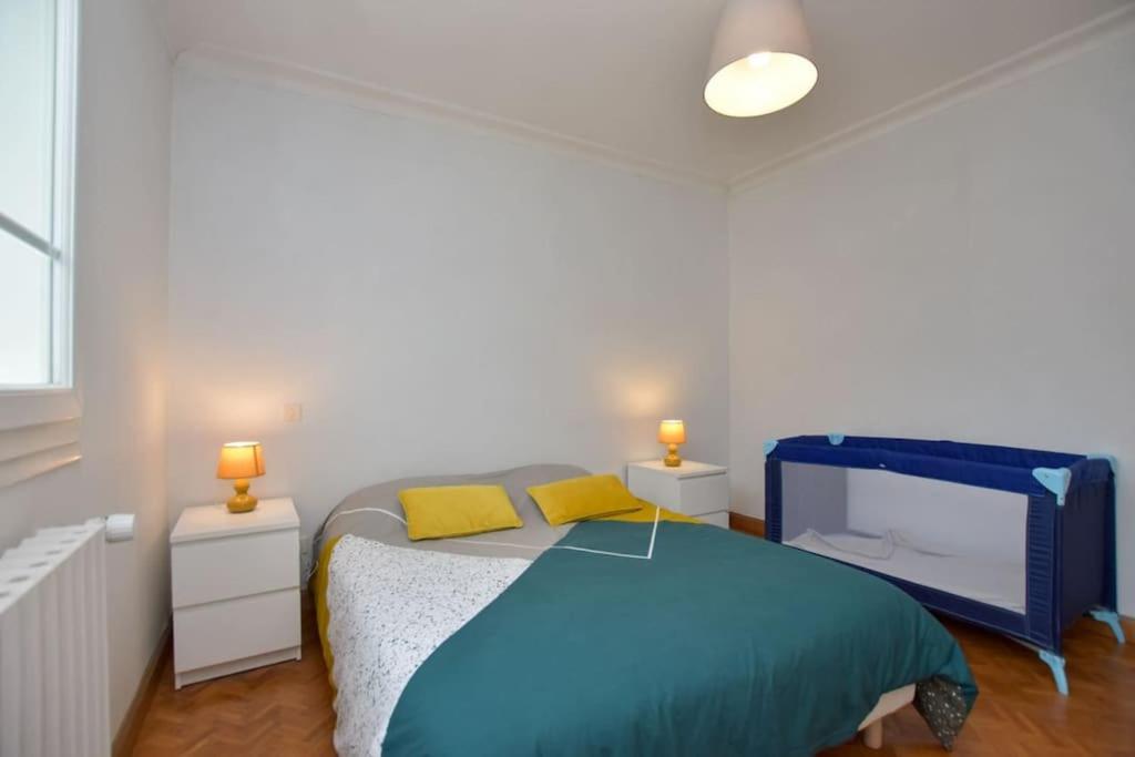 a bedroom with a blue bed with two yellow pillows at « La tranquillité » Villa avec piscine in Saint-Hilaire-de-Riez