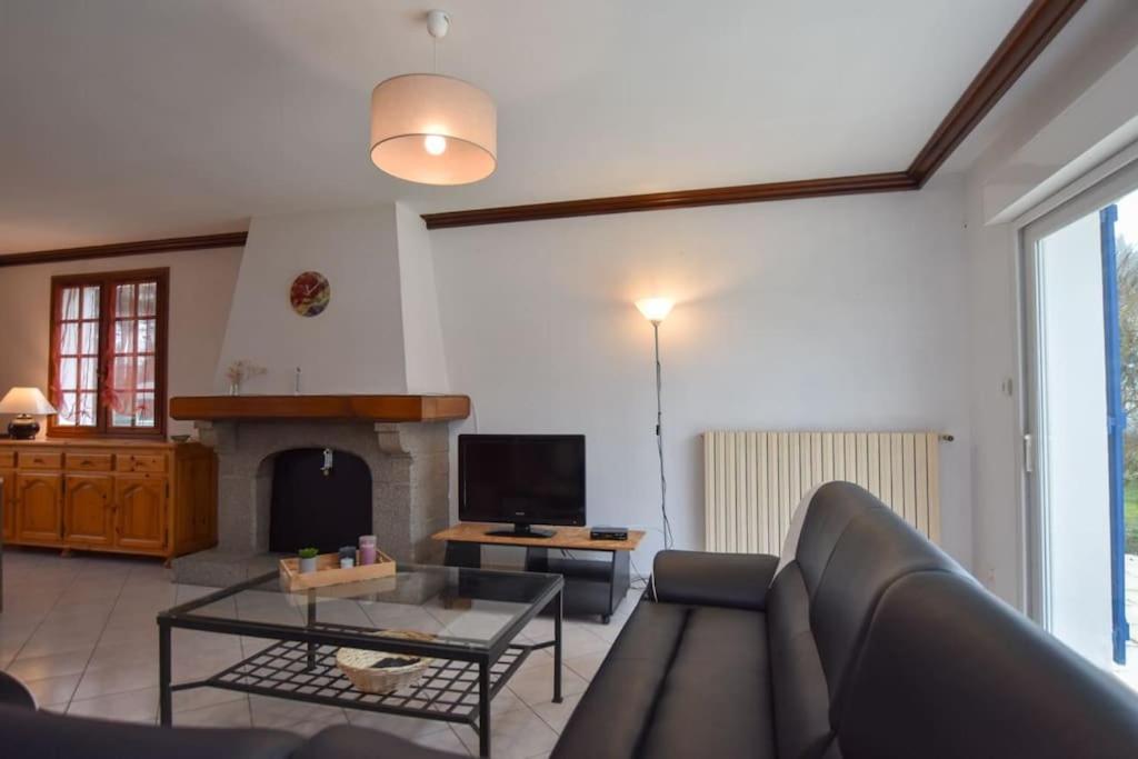a living room with a couch and a fireplace at « La tranquillité » Villa avec piscine in Saint-Hilaire-de-Riez