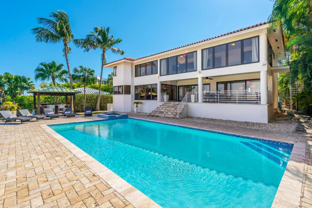 eine Villa mit einem Pool vor einem Haus in der Unterkunft Discover Serenity by the See Your Exclusive Miami Beach Escape! in Miami