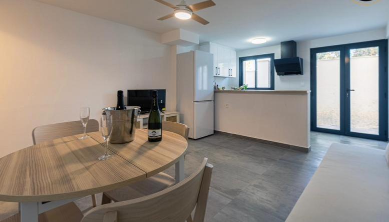 a kitchen and dining room with a table with wine glasses at Top2Stay Los Rosales in Torremolinos