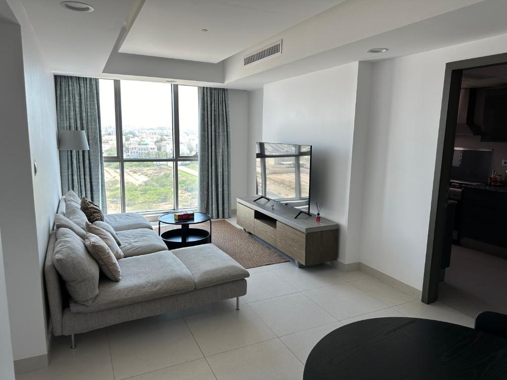 a living room with a couch and a large window at Apartment with Modern Amenities in Muscat