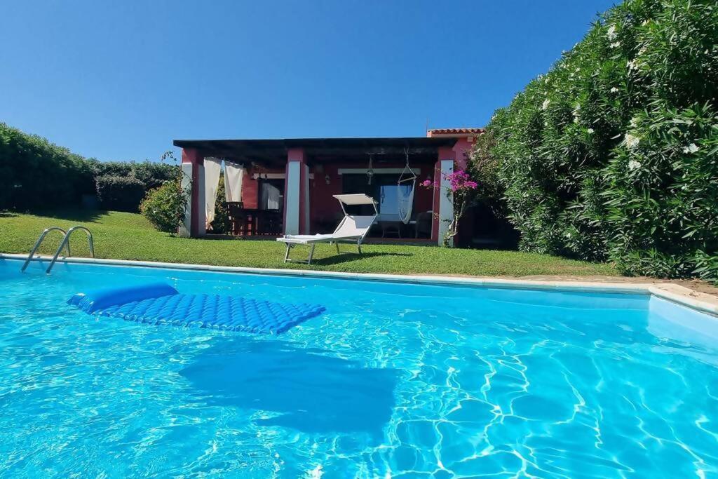 una piscina con una silla frente a una casa en Villa Vianello Piscina privata, en Stintino