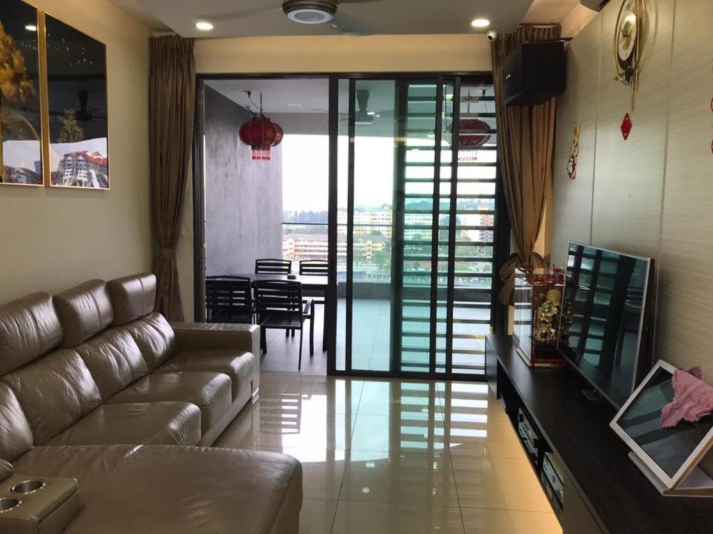 ein Wohnzimmer mit einem Ledersofa und einem Tisch in der Unterkunft Lakepark Residence KL North in Kuala Lumpur