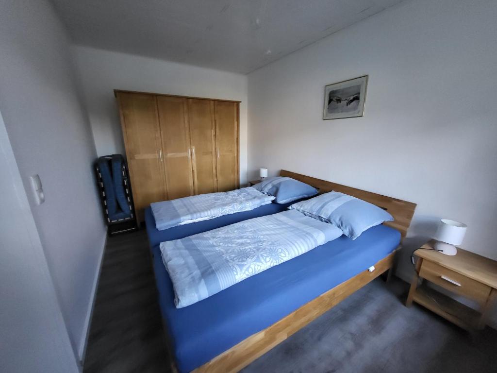 een slaapkamer met een blauw bed en een houten hoofdeinde bij Ferienhof Welling in Horn-Bad Meinberg