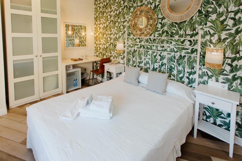 1 dormitorio con cama blanca y pared verde en Hotel MR Costa Blanca, en Denia