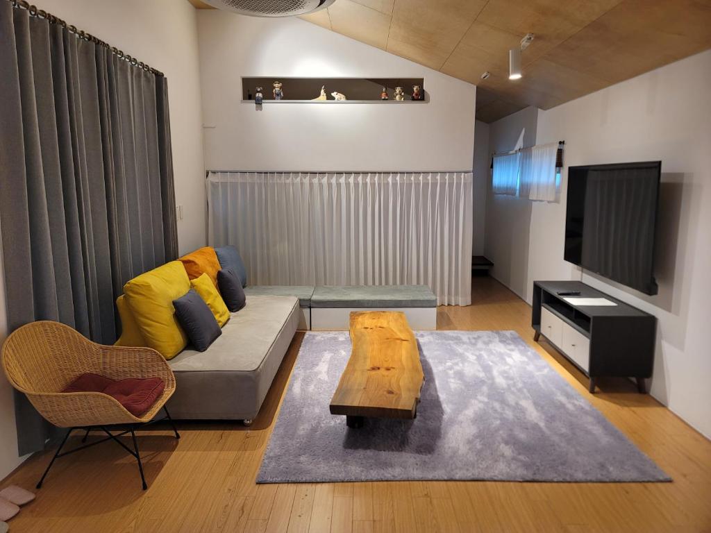 a living room with a couch and a tv at Green Casa in Seogwipo