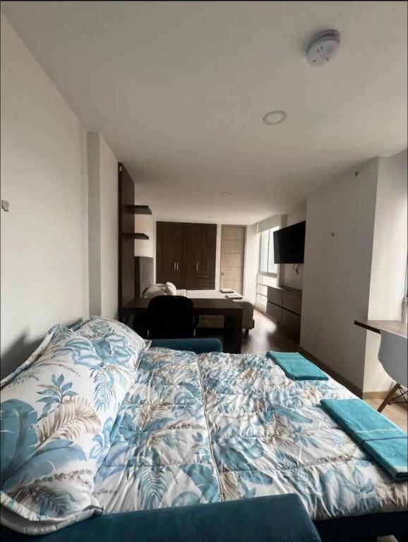 een slaapkamer met een bed en een bureau in een kamer bij Loft en Monserrate in Bogota