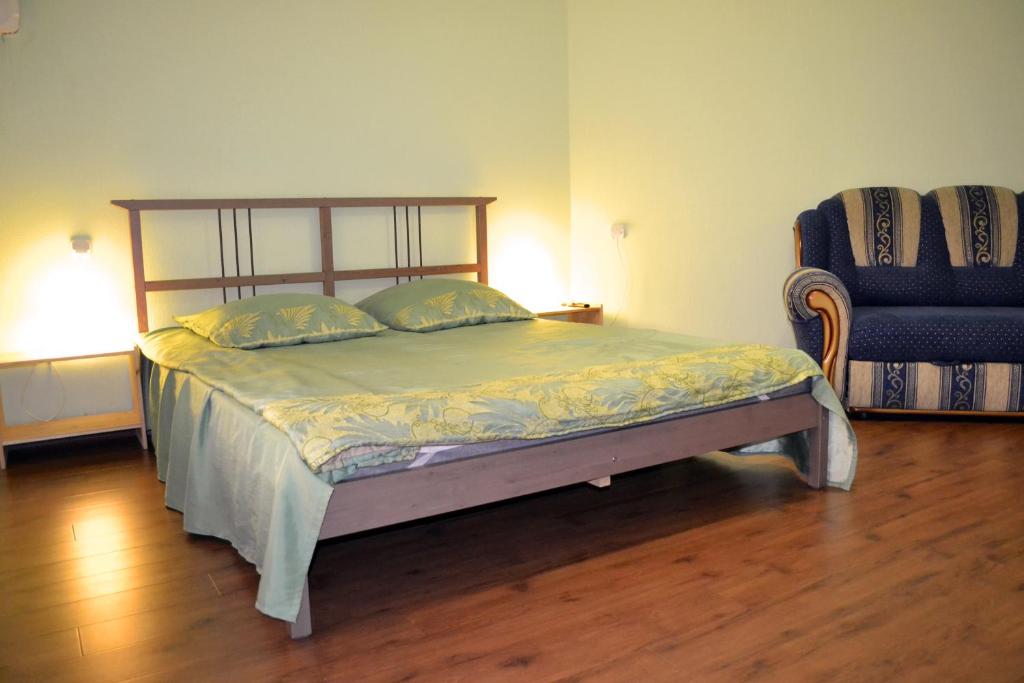 a bedroom with a bed and a chair in a room at Dekabrist Apartment on Proezzhaya 25 in Chita