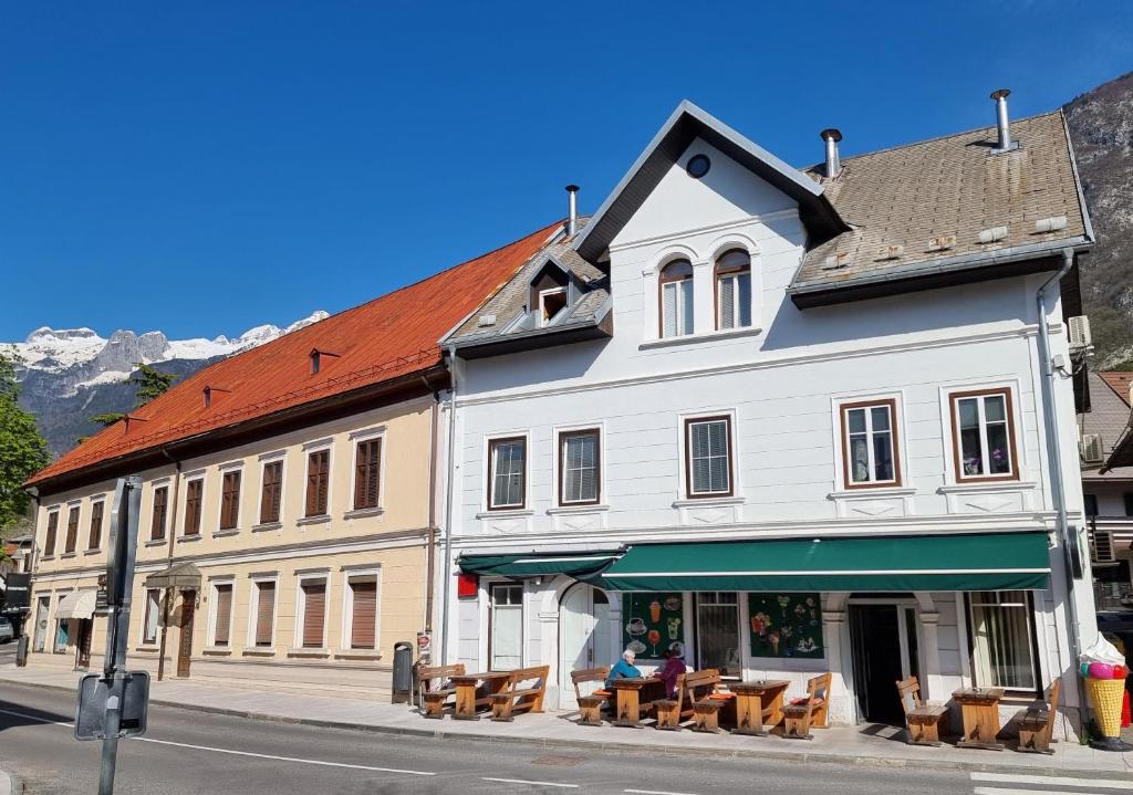 ein Gebäude mit Tischen und Stühlen auf einer Straße in der Unterkunft Apartma Katarina's place in Bovec