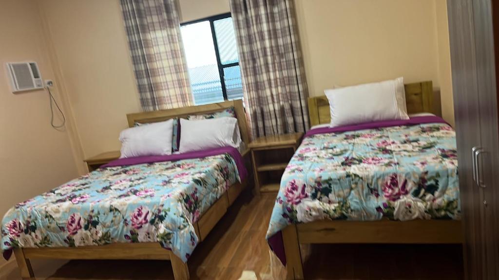 1 dormitorio con 2 camas y ventana en Maxbelle Mountain Resort en Daanbantayan