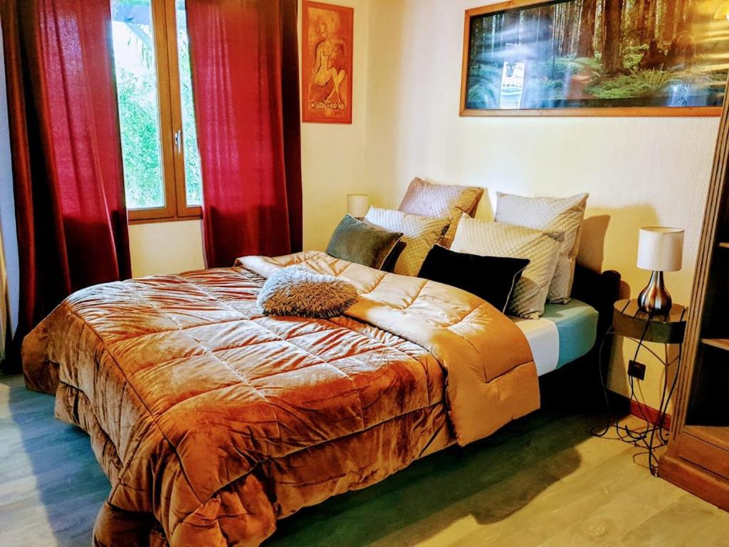1 dormitorio con 1 cama grande y cortinas rojas en Chambres Du Petit Bonheur, en Biscarrosse