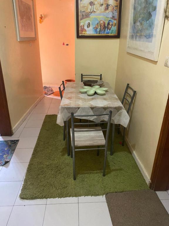 mesa de comedor y sillas con mantel verde en Chez penda, en Dakar