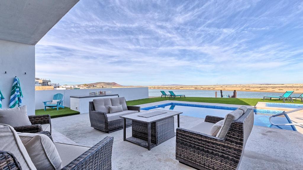 a patio with a table and chairs and a swimming pool at Luxury Retreat Playa Laguna: 5-Bedroom Bliss in Puerto Peñasco