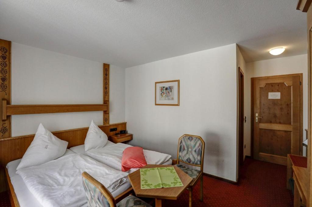 ein Hotelzimmer mit einem Bett, einem Tisch und einem Tisch in der Unterkunft Winzerhof Brachtendorf in Alken