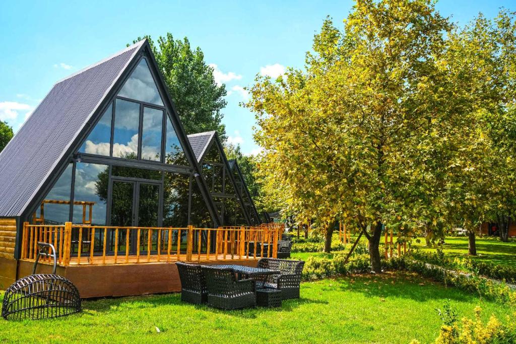 a small cabin with a deck and a tree at KurtköyparkBungalovEvleri in Sakarya