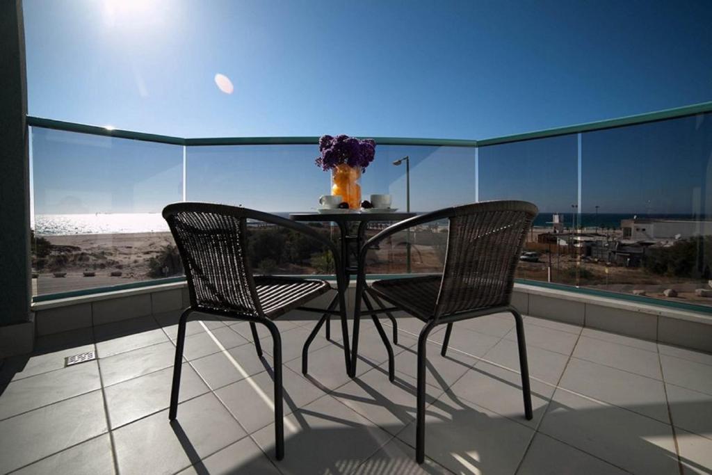 een tafel en 2 stoelen op een balkon met uitzicht bij Regina Goren Hotel in Ashkelon