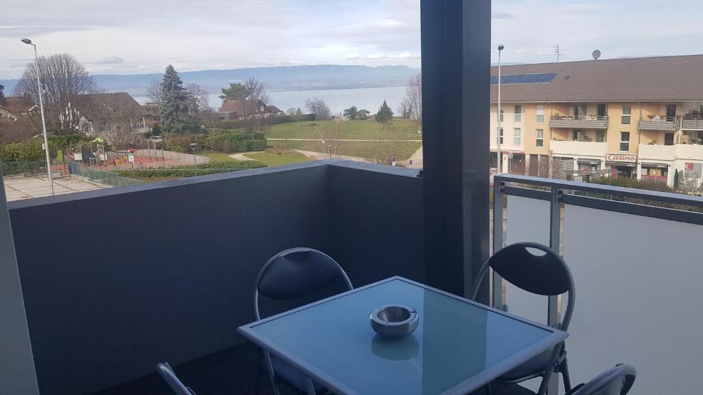 a table and chairs on a balcony with a view at Entre lac et montagnes in Neuvecelle