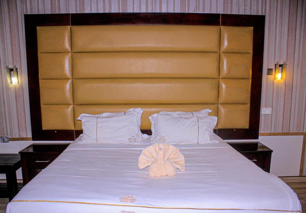 a large bed with a towel on top of it at Makgovango Hotel in Gumare