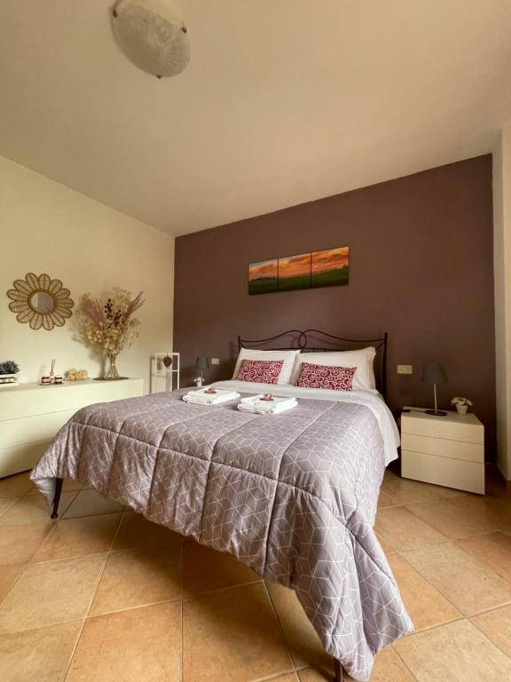 um quarto com uma cama grande e uma parede cinzenta em le piccole sorgenti em Bagni San Filippo