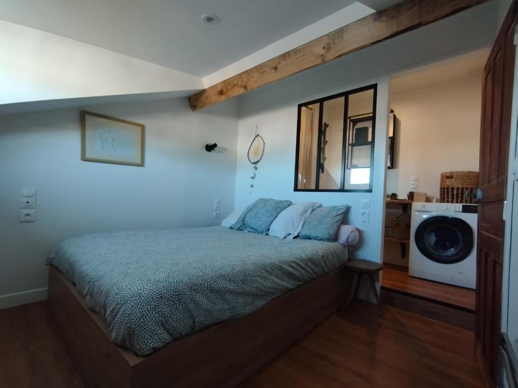 - une chambre avec un lit et un lave-linge dans l'établissement Fargeot, à Saint-Jean-de-Luz
