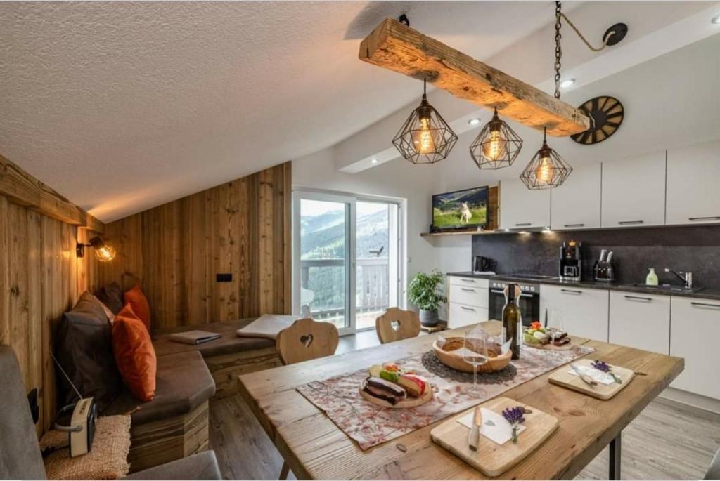 cocina y sala de estar con mesa de madera en Panoramahof Bianca, en Winklern