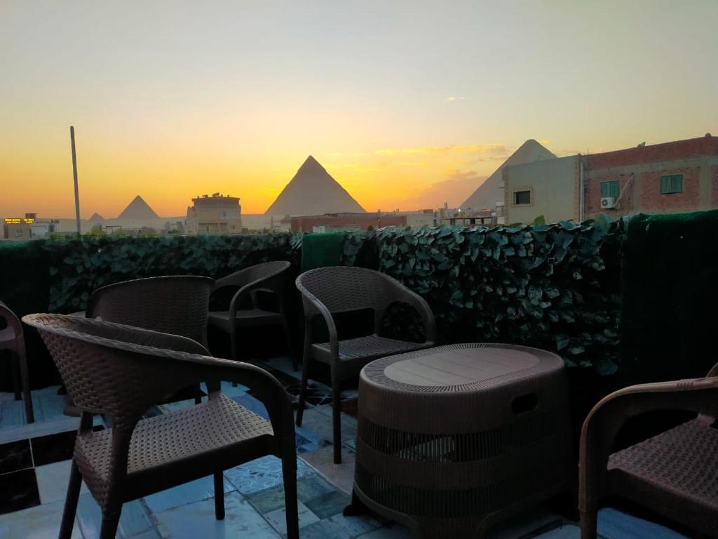 un grupo de sillas sentadas en un balcón con las pirámides en Migo Pyramids View, en El Cairo