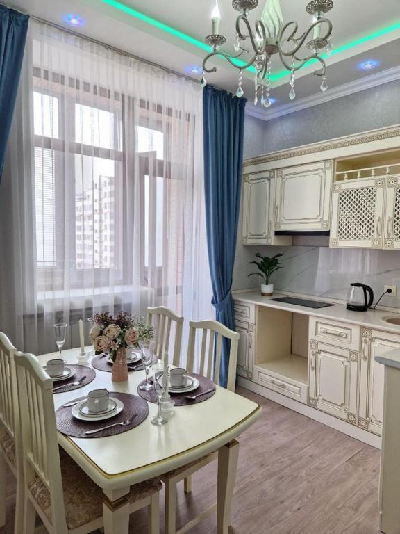 eine Küche mit einem Tisch und Stühlen sowie ein Esszimmer in der Unterkunft Апартаменты в центре города in Aqtau