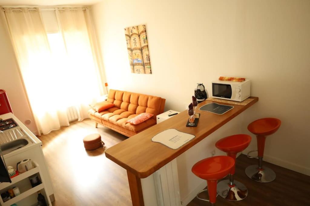 een woonkamer met een bank en een bureau met een laptop bij Jitaku MERAKI in Cagliari