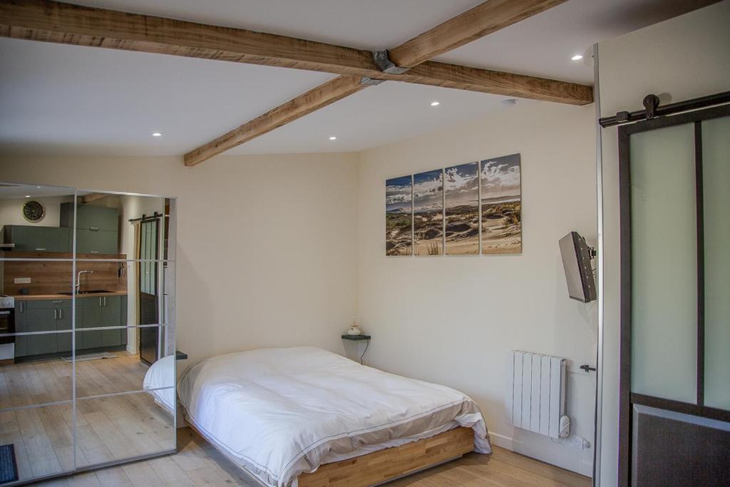a bedroom with a bed and a glass shower at Charmant studio in Saint-Aubin-de-Médoc
