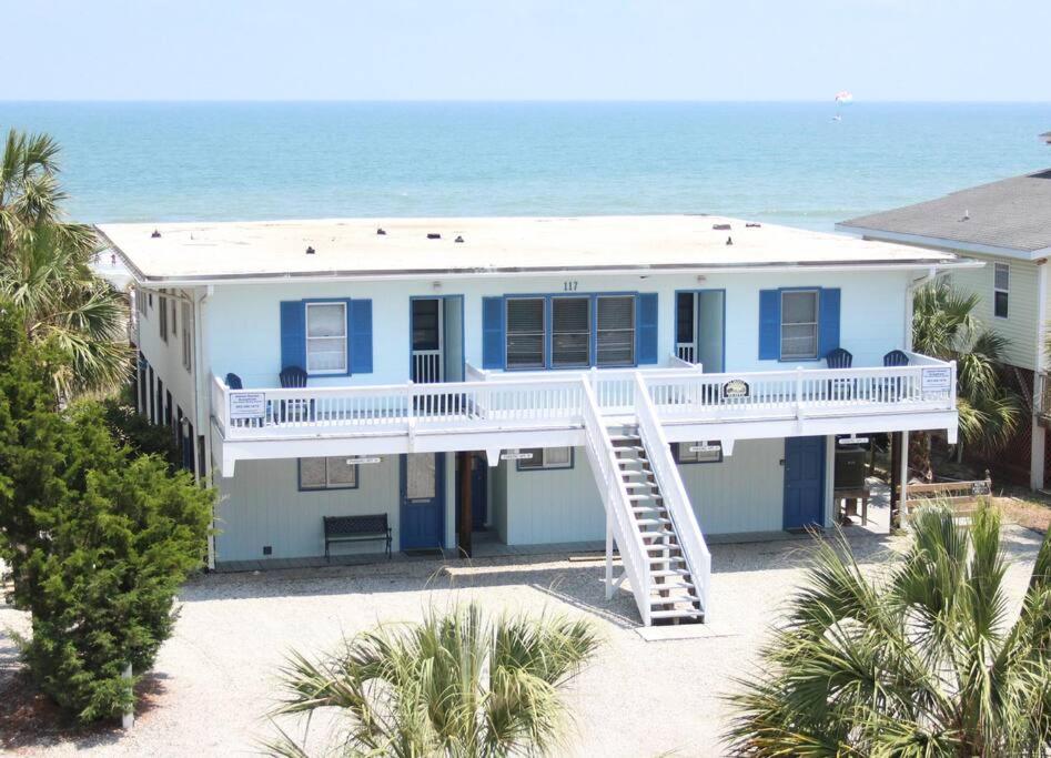 a house on the beach with the ocean in the background at Almost Heaven OCEANFRONT D 3 Bd/3B FREE WIFI in Myrtle Beach