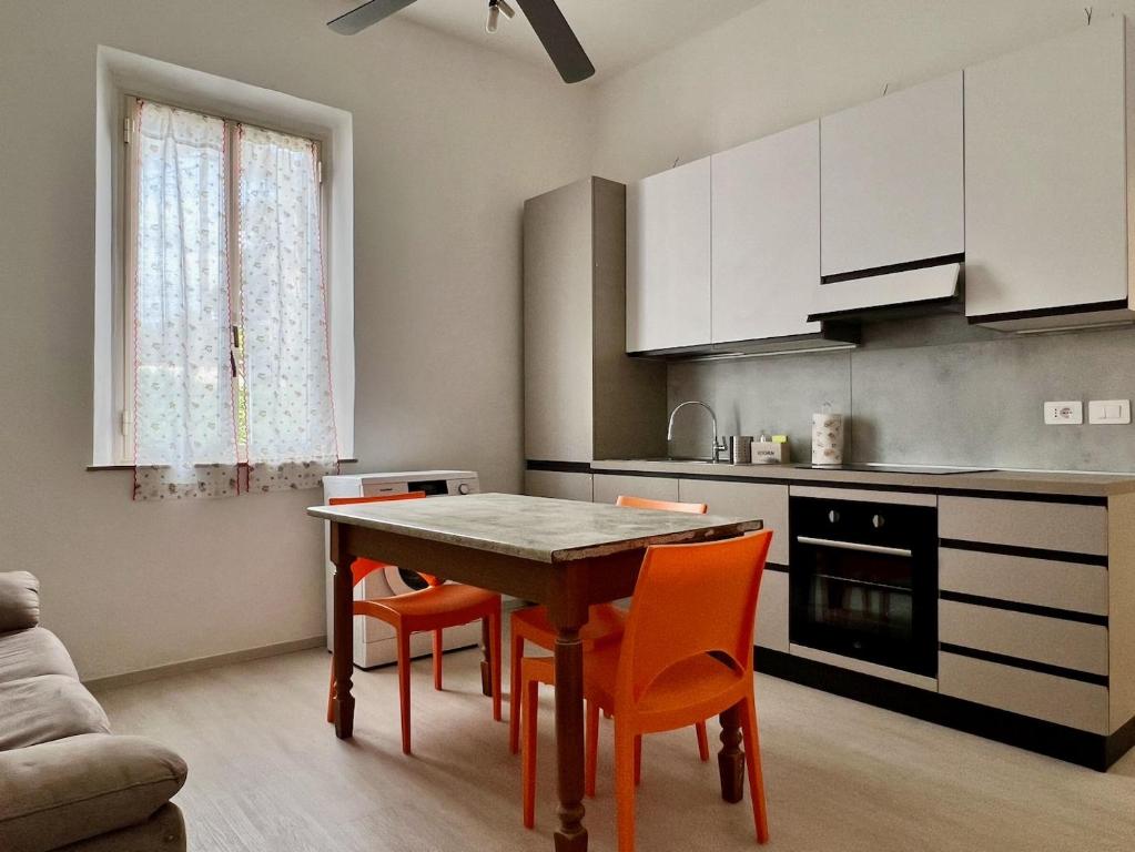 een keuken met een tafel en een aantal oranje stoelen bij Nuovissimo appartamento a Marina di Grosseto in Marina di Grosseto
