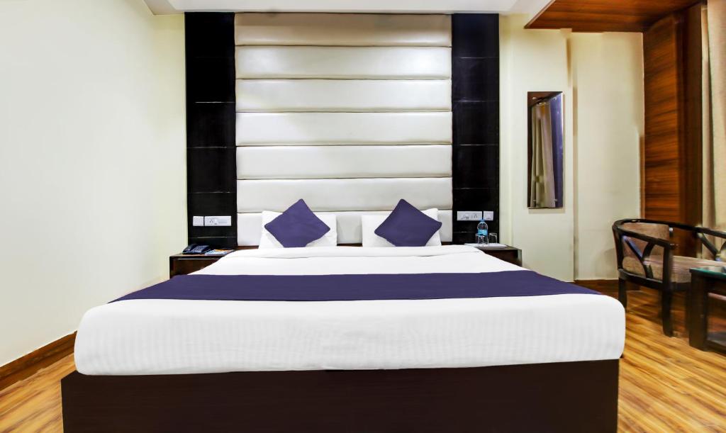 a bedroom with a large bed with blue pillows at HOTEL SKY LARK in Chandīgarh