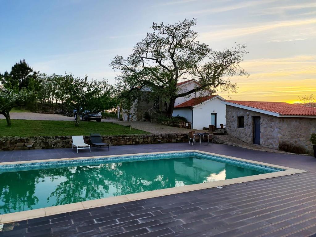 a swimming pool in front of a house at Quinta dos Carvalhais - Serra da Estrela in Fornos de Algodres