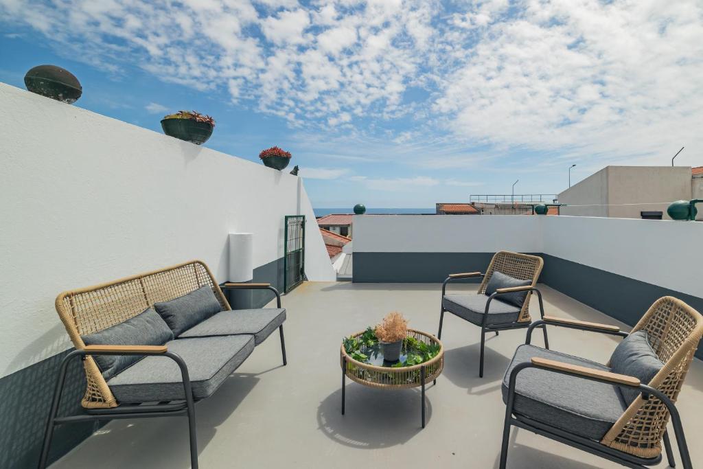 eine Terrasse mit Stühlen und einem Tisch auf dem Dach in der Unterkunft OCEAN VIEW House (airport&city) in Ponta Delgada