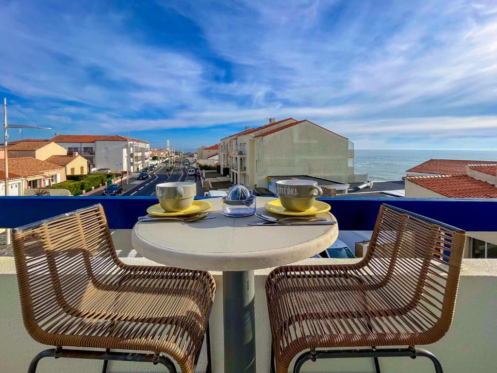 a table and chairs on a balcony with a view of the ocean at Spacieux appartement quartier de La Chaume - 4 pers in Les Sables-dʼOlonne