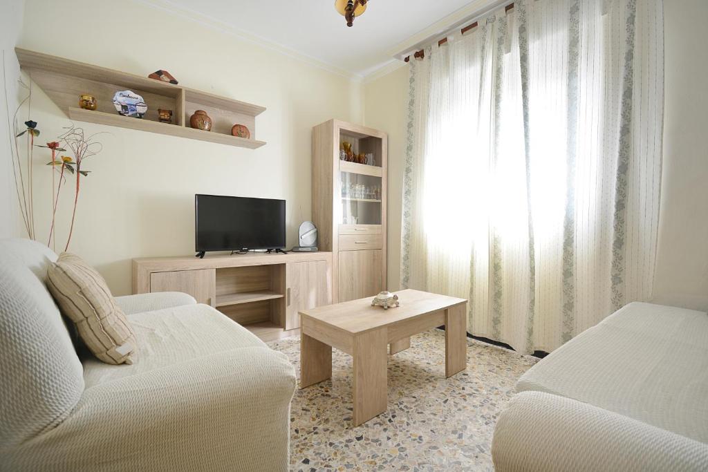 un soggiorno con divano, TV e tavolo di Apartamento con vistas al mar en Combarro a Combarro