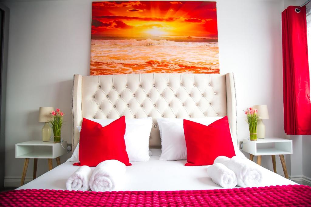 a bedroom with a white bed with red pillows at Lucky Home - Ideal for Trade, Consultants & Family - Near Alton Towers, 3 Bedrooms - 4 Beds - Max 5 Guests in Stoke on Trent