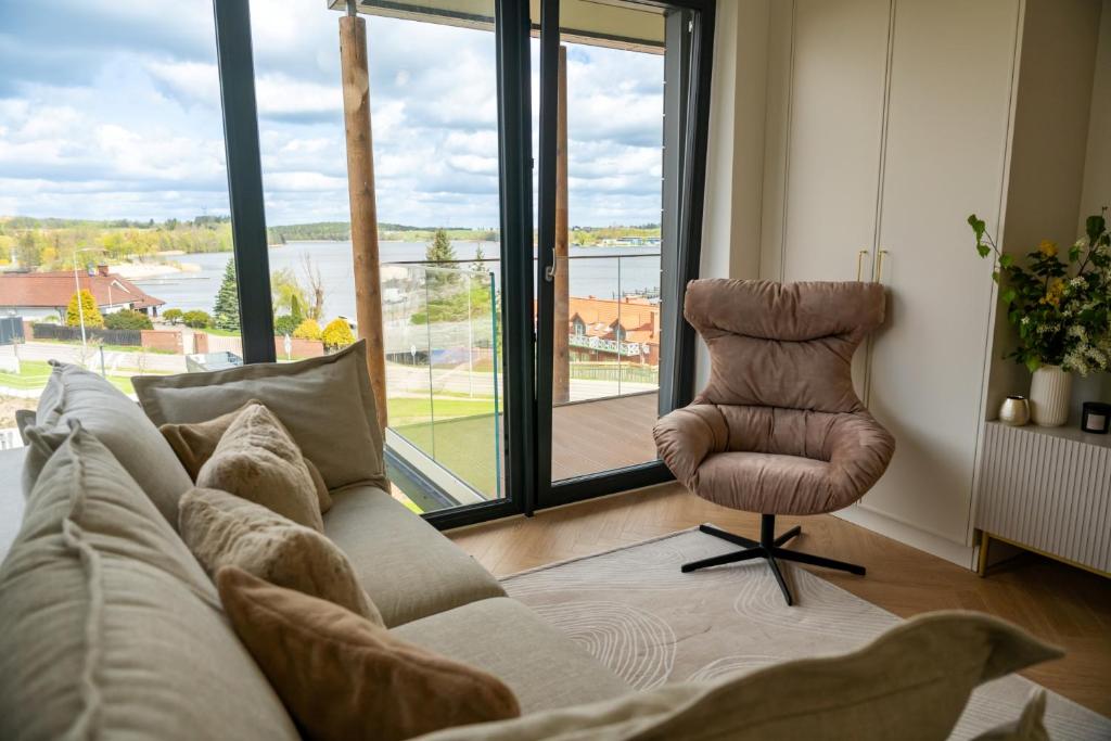 - un salon avec un canapé et une chaise dans l'établissement Lake Rental Pratum 43, à Mikołajki
