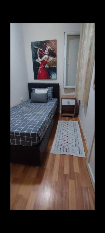 a bedroom with a bed and a window and a rug at Alsancak seaside 50 m Single room green in Konak