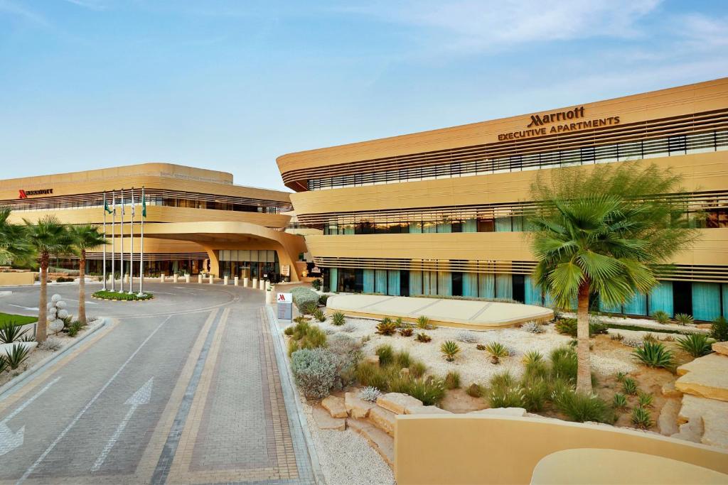 widok na budynek z palmami przed nim w obiekcie Marriott Riyadh Diplomatic Quarter w Rijadzie