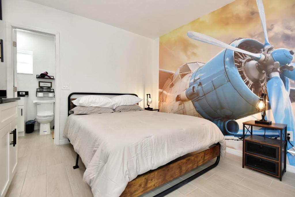 un dormitorio con una pintura de un avión en la pared en Blue Mist Motel - Room # 3, en Daytona Beach
