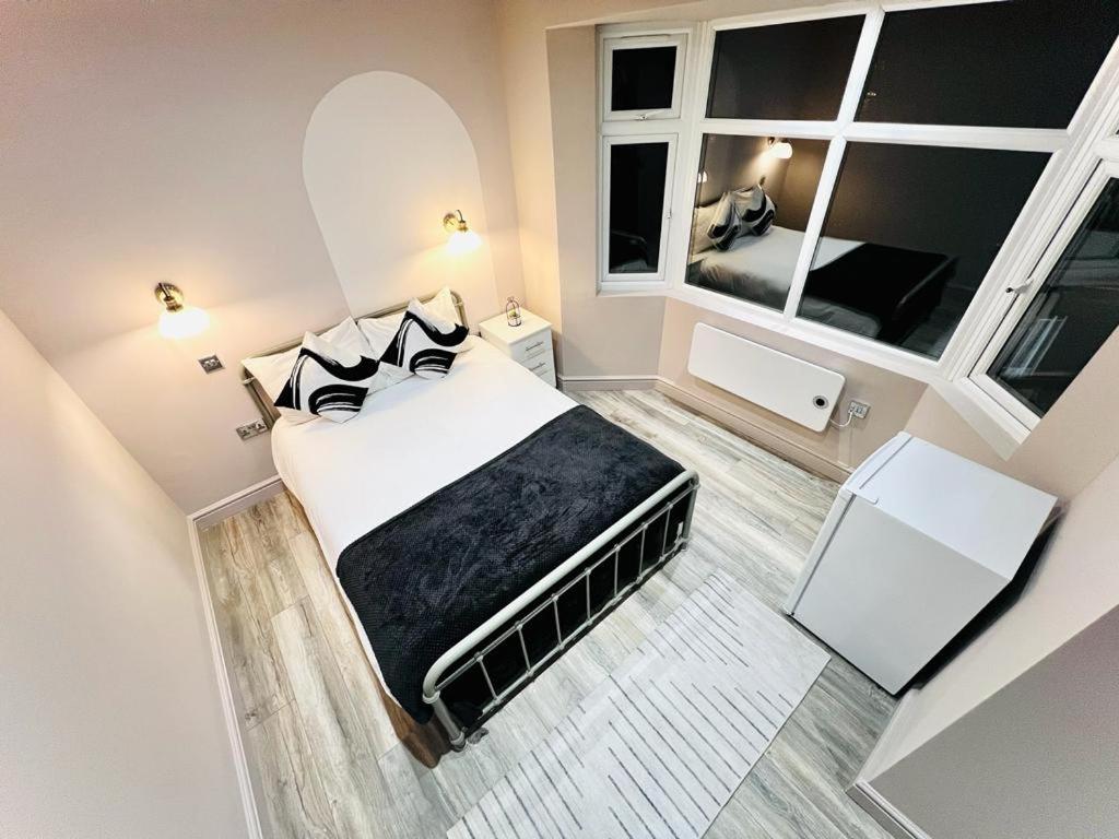 High Standard Room, Super Location في لندن: غرفة نوم بسرير كبير ونوافذ
