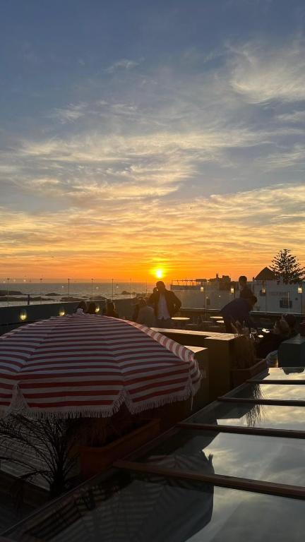 an umbrella on the roof of a building with the sunset at Le Palazzo in Essaouira