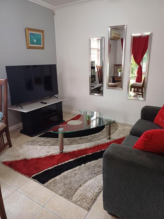 a living room with a couch and a tv and mirrors at The Royal at winchester in Kingston