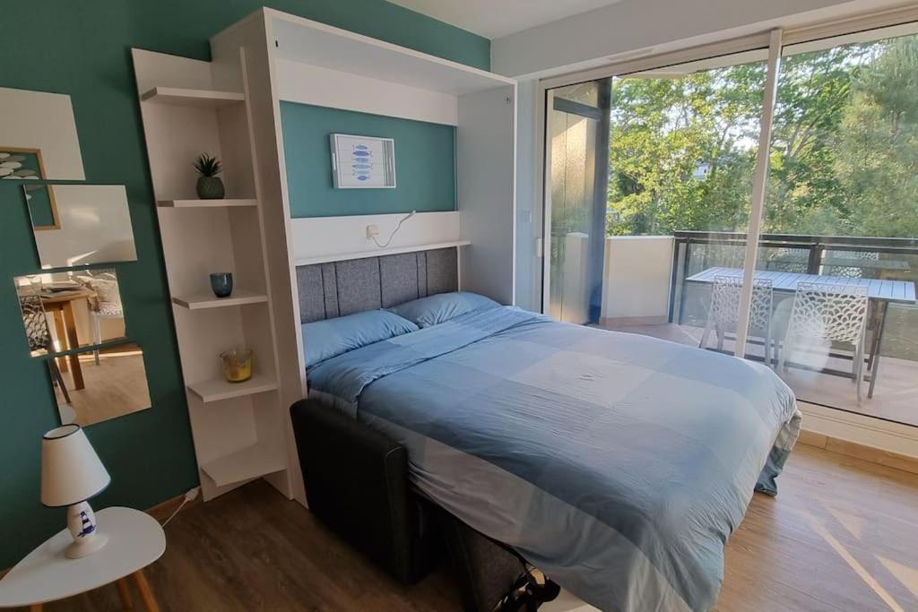 ein Schlafzimmer mit einem Bett und einem großen Fenster in der Unterkunft Bulle de fraîcheur - Studio confort sur la plage in La Baule
