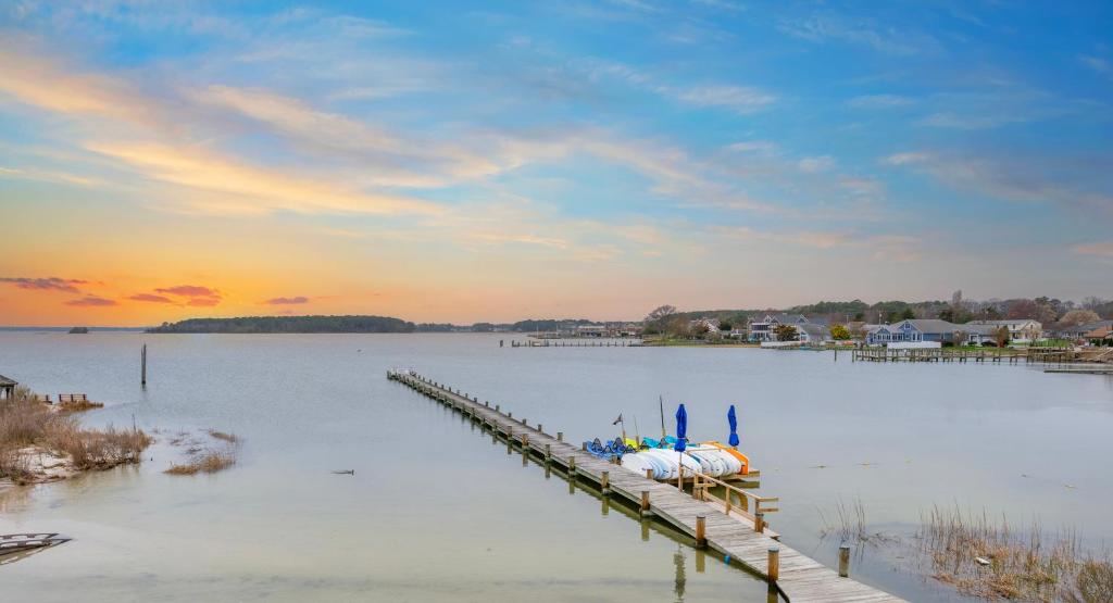 a dock on a lake with a boat on it at The Bay Resort in Dewey Beach