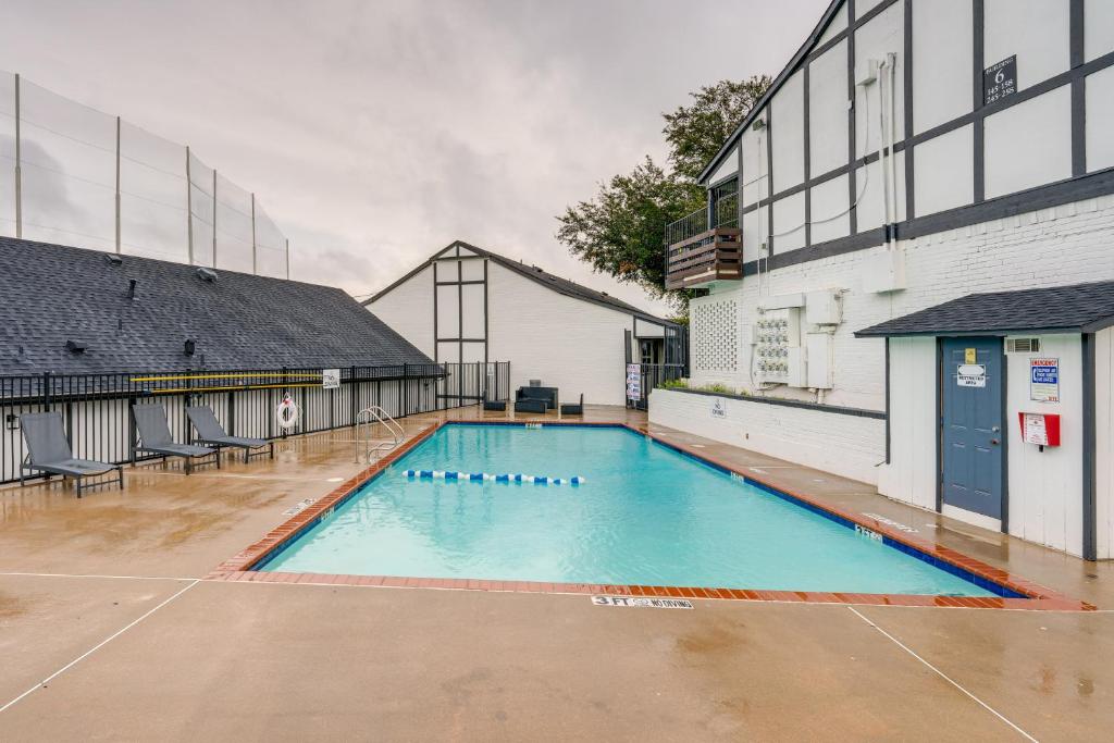 an empty swimming pool in front of a building at Charming Dallas Apt with Fireplace and Pool Access! in Dallas