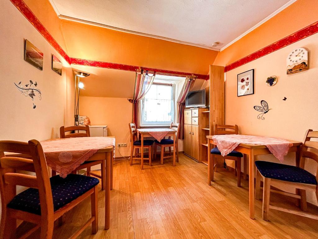ein Esszimmer mit Tischen, Stühlen und einem Fenster in der Unterkunft Gästezimmer Bruno in Bremm