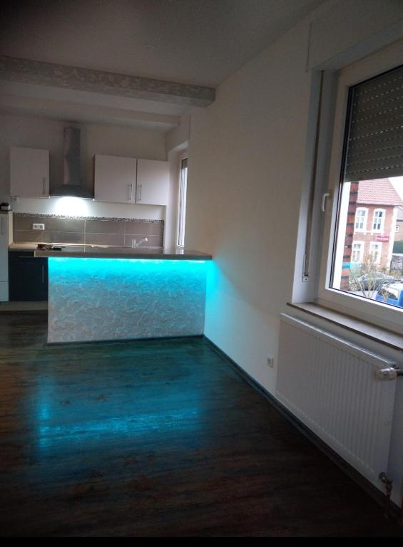 um quarto vazio com uma cozinha com iluminação azul em Apartament mit eine Schlafzimmer Ferienwohnung em Warendorf