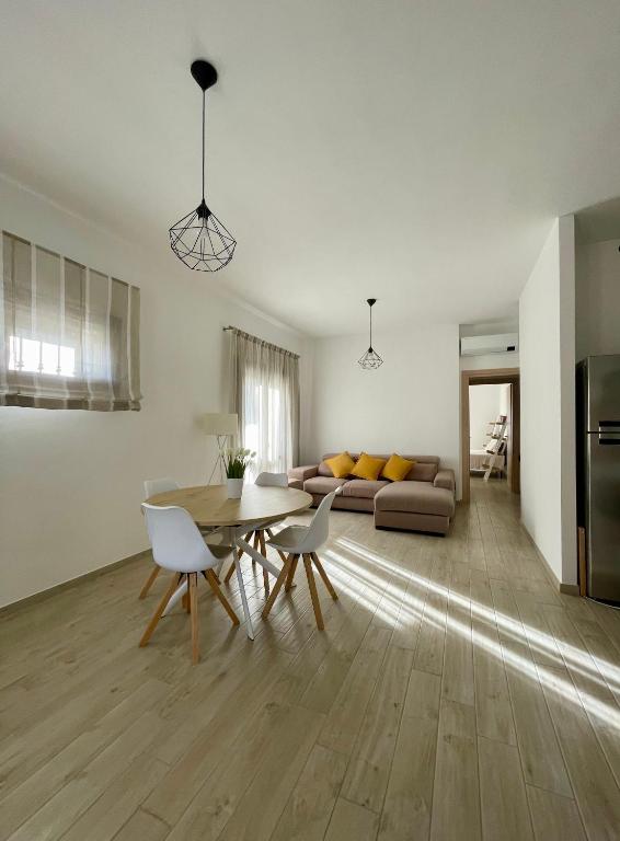 a kitchen and living room with a table and chairs at Dimora La Coccinella - Accommodation in Muravera